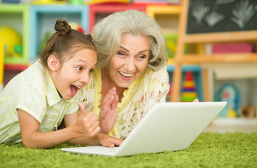 grandmother and daughter using laptop