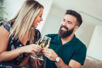 Smiling couple dating and drinking wine at home
