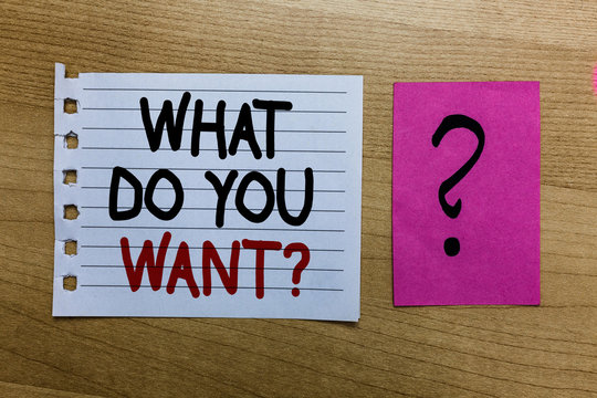 Conceptual hand writing showing What Do You Want question. Business photo text Tell me your desires requests demands ambition white page on wooden desk with words violet with question mark.