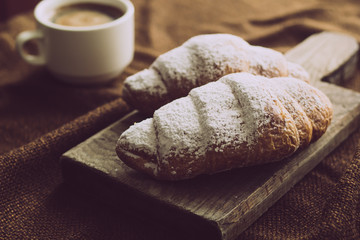 Freshly baked croissants with a cup of hot coffee. 