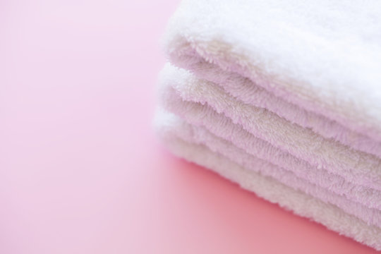 Spa. White Cotton Towels Use In Spa Bathroom on Pink Background. Towel Concept. Photo For Hotels and Massage Parlors. Purity and Softness. Towel Textile