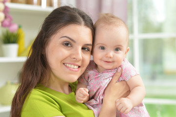 young woman with  baby girl at home