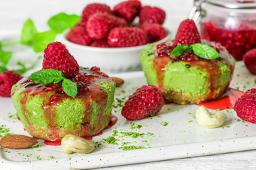 homemade raw matcha powder cakes with fresh raspberries, jam, mint, nuts. healthy vegan food concept