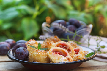Plum dumplings coverder with breadcrumb and sprinkled with sugar. Homemade dessert with dough and plums.