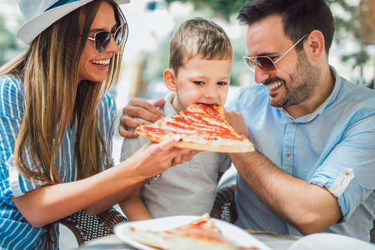 Portrait of happy family spending time in pizzeria