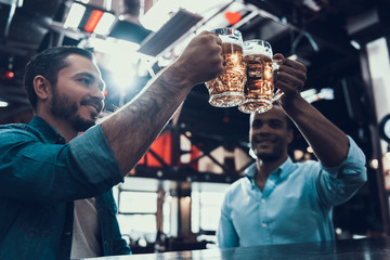 Young Smiling Men Drinking Beer in Modern Bar.