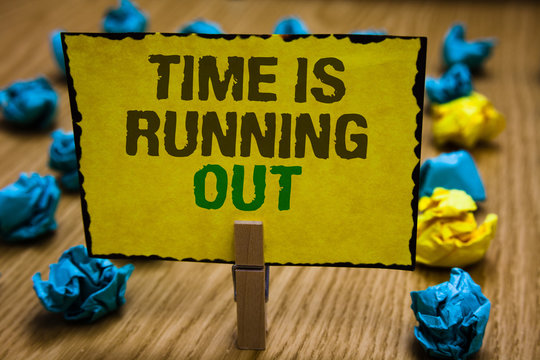 Writing note showing Time Is Running Out. Business photo showcasing Deadline is approaching Urgency things cannot wait Paperclip grip yellow page with text woody floor blue and yellow lob.