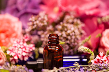 flowers and bottles of essential oils for aromatherapy