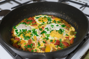 Morning Breakfast of fried eggs with vegetables and fresh herbs.