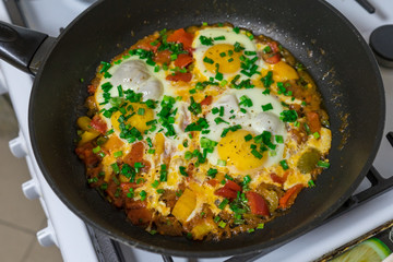 Morning Breakfast of fried eggs with vegetables and fresh herbs.