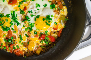 Morning Breakfast of fried eggs with vegetables and fresh herbs.