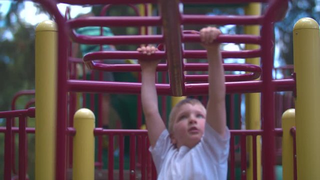 Slow-motion footage of a boy in a white shirt swinging on monkey bars towards the camera. Shot on a Blackmagic Ursa Mini Pro 4.6k with a Sigma 50-100mm f/1.8.