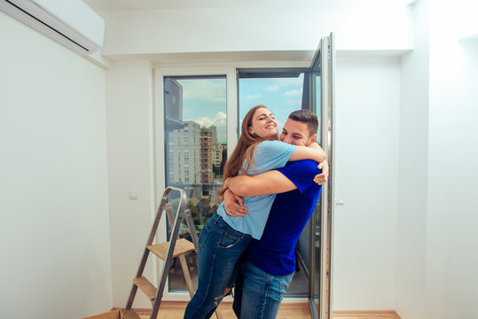 Happy family couple embracing in a new house. Young family moving in a new apartment concept.