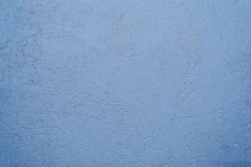 texture of the surface of the wall covered with decorative plaster of the woodworm type