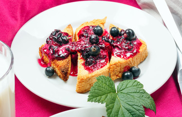 Delicious toasts bread with homemade currant jam with milk