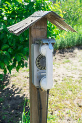 Old street disk wired phone. The village telephone booth.