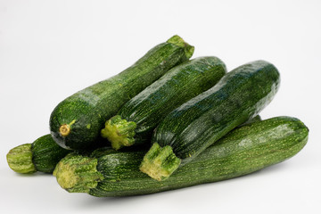 Zucchini on a white table. Tailor measure to measure the waist circumference during the diet.