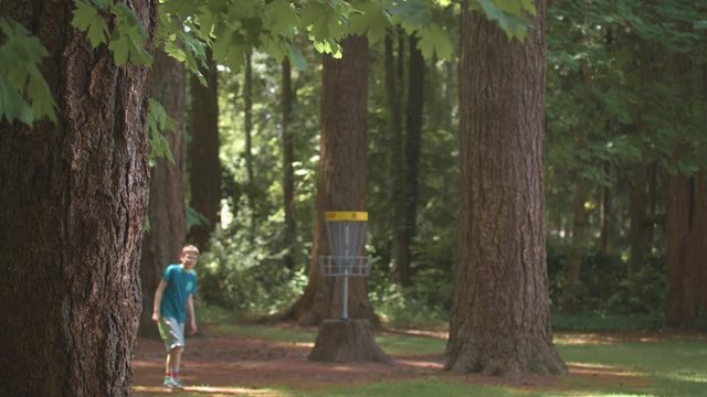 Boy walking in front of a frisbee golf basket.  Shot on a Blackmagic Ursa Mini Pro 4.6k with a Sigma 50-100mm f/1.8.