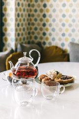Sweet treats and tea on the table in the stylish modern designed apartments