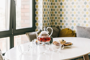 Sweet treats and tea on the table in the stylish modern designed apartments