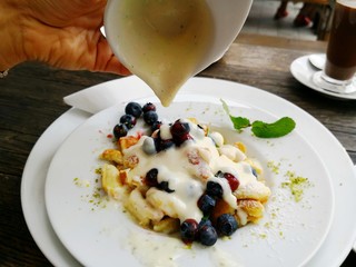 Woman eating Kaiserschmarren traditional Austrian and Southern German dessert dish