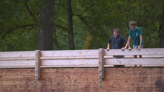 Slow-motion footage of two boys looking over and spitting over a wooden footbridge.  Shot on a Blackmagic Ursa Mini Pro 4.6k with a Sigma 50-100mm f/1.8.