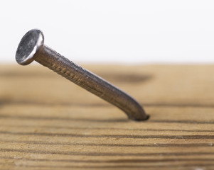 Steel  nail hammered into a wood board