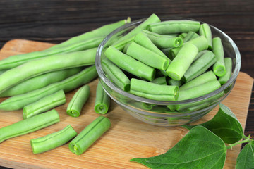 Green beans in the bowl on wooden table