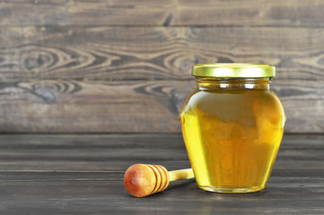 Honey jar on wooden background