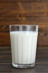 Glass of milk on wooden background