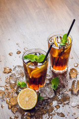Traditional ice tea, chilled, with lemon, mint and ice on rustic table