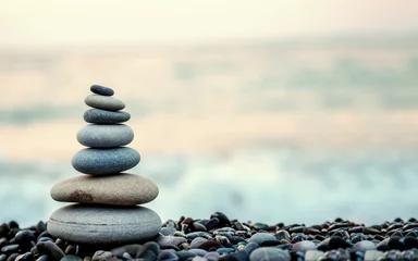 Foto op Plexiglas gemaakt van stenen toren op het strand en wazige achtergrond © oktay