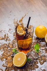 Splash. Traditional ice tea, chilled, with lemon, mint and ice on rustic table