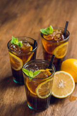 Traditional ice tea, chilled, with lemon, mint and ice on rustic table
