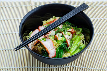 Yellow noodles served with sliced red pork