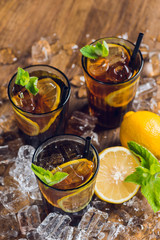 Traditional ice tea, chilled, with lemon, mint and ice on rustic table