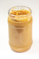 A jar of organic peanut butter sitting on the kitchen table waiting to be eaten 