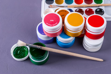 Desk of an artist with watercolor paints and paintbrushes
