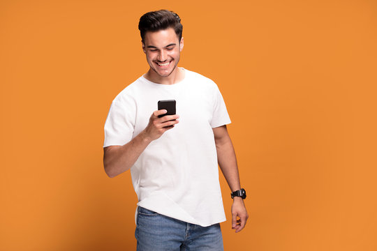 Smiling Handsome Man With Mobile Phone On Yellow Background.