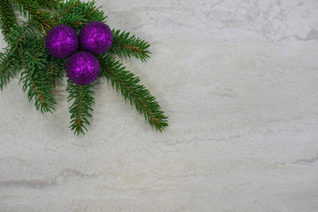 three purple ornaments on a spruce bough