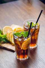 Traditional ice tea, chilled, with lemon, mint and ice on rustic table