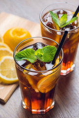 Traditional ice tea, chilled, with lemon, mint and ice on rustic table
