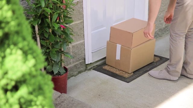 A female picks up a package from outside his front door