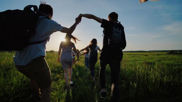 Happy senior pupils flee and toss their portfolios against the sunset. Happy ending school days.