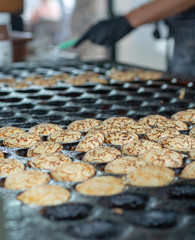 Making small pancakes, traditional Dutch poffertjes on street market