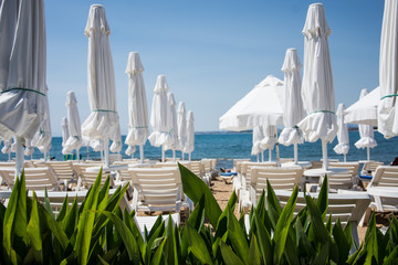 Obraz premium Rest by the sea. Beach with sun loungers. warm countries. Chaise lounge. Place for sunburn. Solar procedures. Side, Turkey