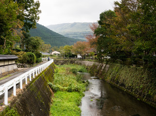 Fototapeta premium Charming riverside street in Yufuin, a famous hot spring resort in Oita prefecture, Japan
