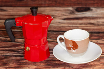 An expresso maker next to an expresso glass on the kitchen table