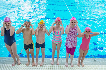 happy children kids group at swimming pool class learning to swim