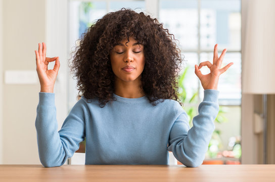 African american woman at home relax and smiling with eyes closed doing meditation gesture with fingers. Yoga concept.